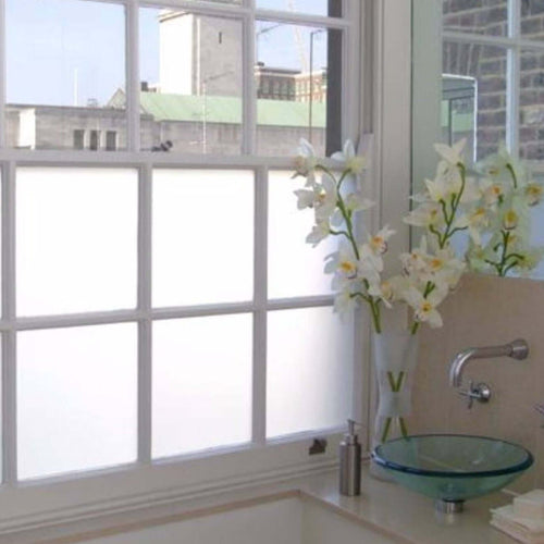 Frosted window film providing privacy while enhancing natural light in a stylish bathroom.