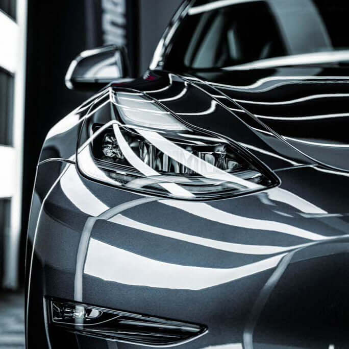 XPEL Lakkbeskyttelse SGN BASE applied on a sleek gray car exterior showcasing its glossy finish.