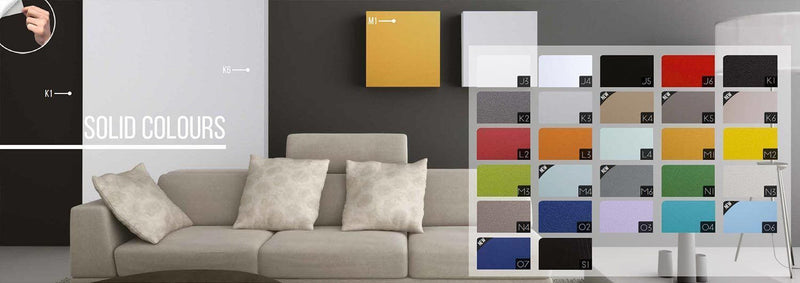 Display of solid color furniture foils on a wall with a sofa, showing various color options available.